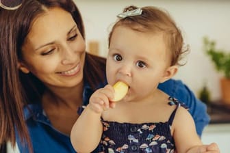 Mehr ein Knabbern und Ausprobieren als echtes Essen: Babys erhalten nach einigen Monaten zur Milch die erste Beikost.