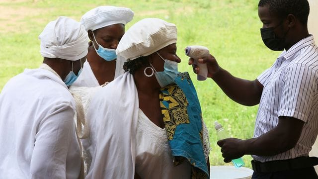 In Simbabwes Hauptstadt Harare lassen Menschen ihre Temperatur überprüfen.