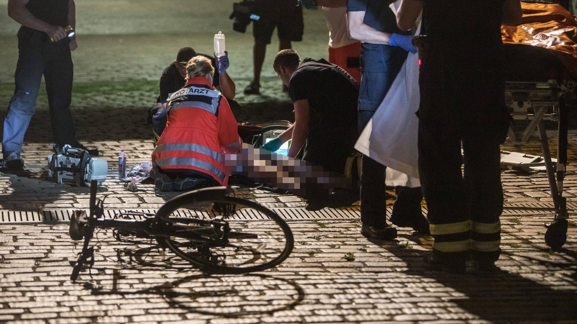 Rettungskräfte versorgen einen Verletzten nach einem Fahrradunfall (Symbolbild): Der 75-jähriger Fußgänger wurde beim Zusammenstoß schwer verletzt.