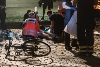 Rettungskräfte versorgen einen Verletzten nach einem Fahrradunfall (Symbolbild): Der 75-jähriger Fußgänger wurde beim Zusammenstoß schwer verletzt.