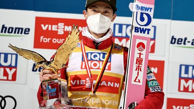 Ryoyu Kobayashi jubelt mit dem Pokal für den Gesamtsieger, einem goldenen Adler, über den Gesamtsieg der Vierschanzentournee.