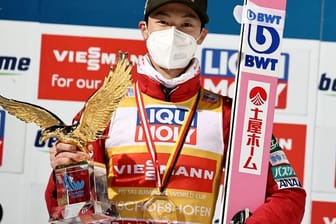 Ryoyu Kobayashi jubelt mit dem Pokal für den Gesamtsieger, einem goldenen Adler, über den Gesamtsieg der Vierschanzentournee.