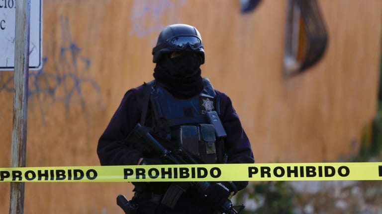 Ein Soldat steht vor einem Tatort in Mexiko (Symbolbild): Unbekannte haben ein Auto voller Leichen vor einem öffentlichen Gebäude abgestellt.