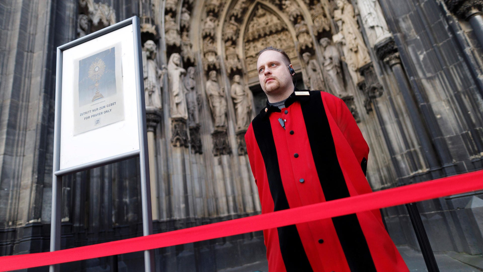 Ein Domschweizer vor dem Eingang des Kölner Doms (Symbolbild): Klimaaktivisten haben einen Gottesdienst im Kölner Dom unterbrochen.