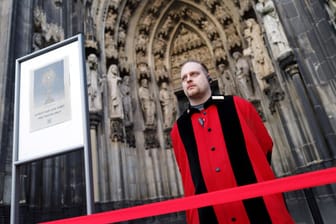 Ein Domschweizer vor dem Eingang des Kölner Doms (Symbolbild): Klimaaktivisten haben einen Gottesdienst im Kölner Dom unterbrochen.