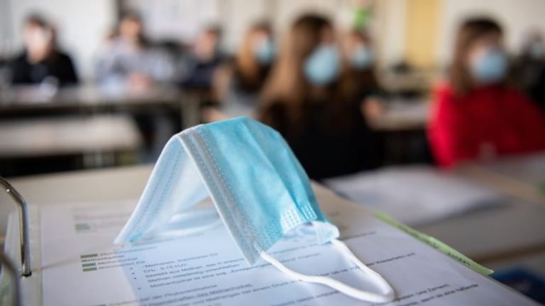 Ein Mund-Nasen-Schutz liegt im Unterricht auf Unterlagen (Symbolbild): Der Sonderausschuss wurde im Jahr 2020 gegründet.
