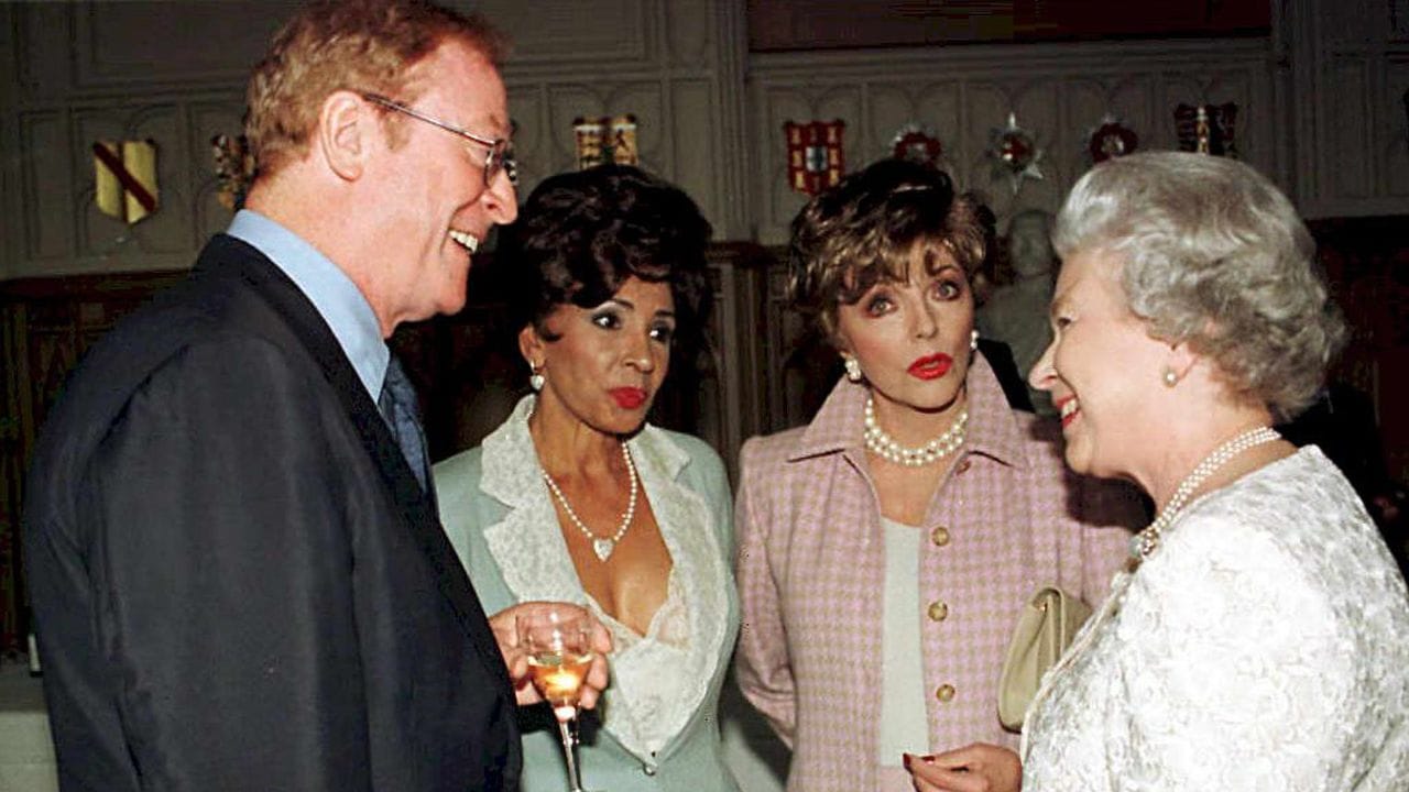 Schauspieler Michael Caine (l-r), Sängerin Shirley Bassey und Schauspielerin Joan Collins unterhalten sich mit Königin Elizabeth II. Schauspieler Michael Caine (l-r), Sängerin Shirley Bassey und Schauspielerin Joan Collins unterhalten sich mit Königin Elizabeth II.