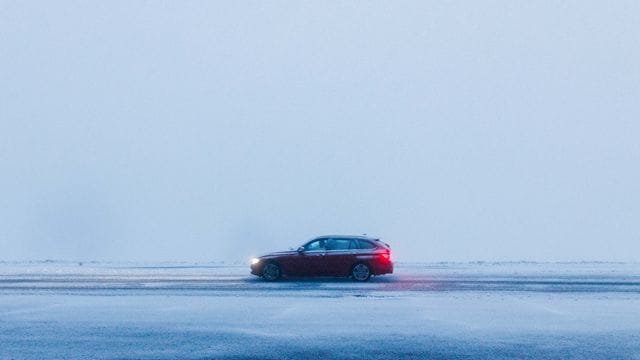 Ein Auto fährt über eine schneebedeckte Straße