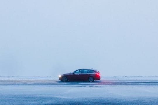 Ein Auto fährt über eine schneebedeckte Straße