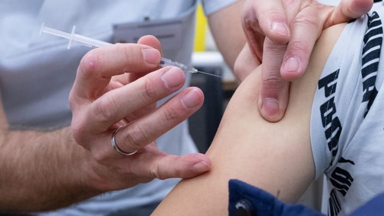 Ein Impfarzt verabreicht in einer Kinder-Impfstation einem Jungen eine Impfdosis.