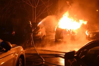 Die Feuerwehr löscht die lodernden Flammen: Zwei der Autos brannten vollständig aus.