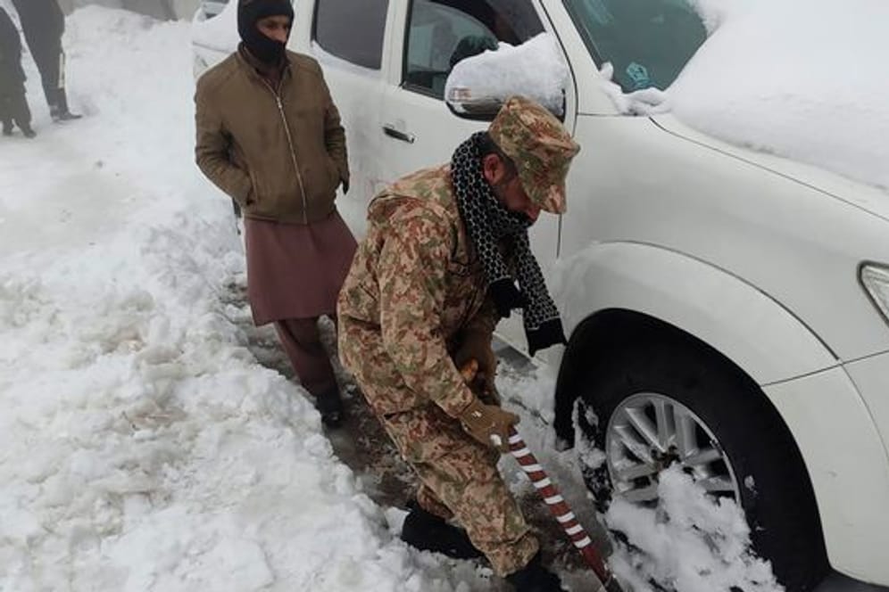 Nichts geht mehr, ein Soldat hilft: Nach einem heftigen Wintereinbruch im Norden Pakistans sind mindestens 21 Urlauber ums Leben gekommen.