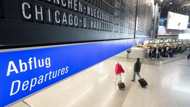 Reisegäste gehen an einem Flughafen zum Abflugterminal