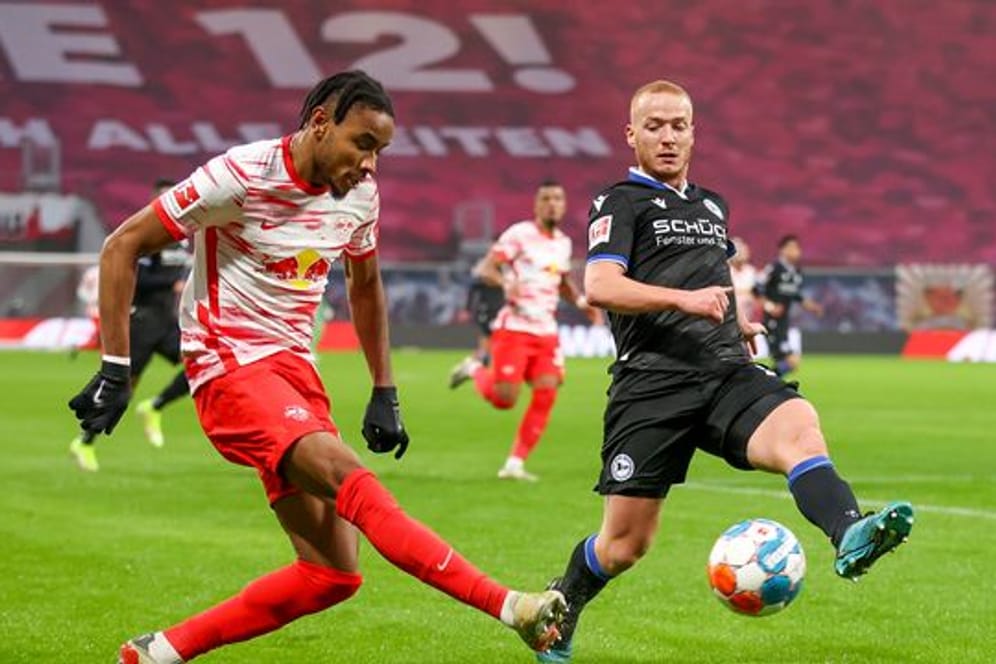 Leipzigs Christopher Nkunku (l) sitzt gegen den FSV Mainz 05 nur auf der Bank.