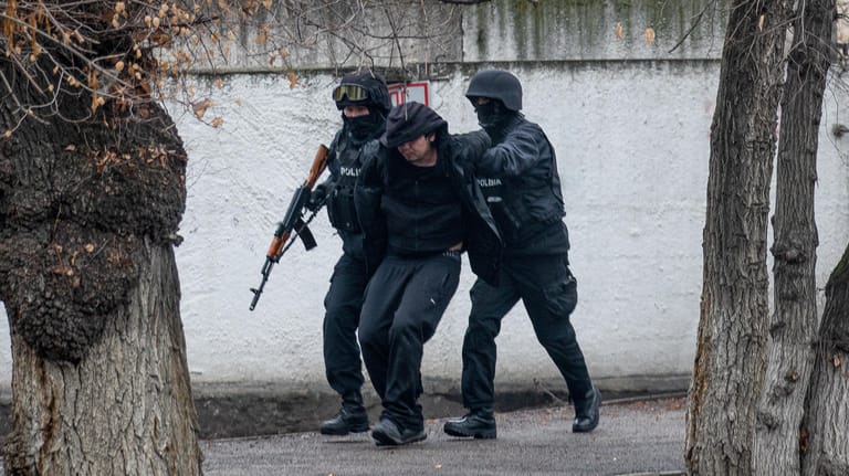 Bewaffnete Bereitschaftspolizisten halten einen Demonstranten in Almaty fest: Die Unruhen in dem zentralasiatischen Land Kasachstan halten an.