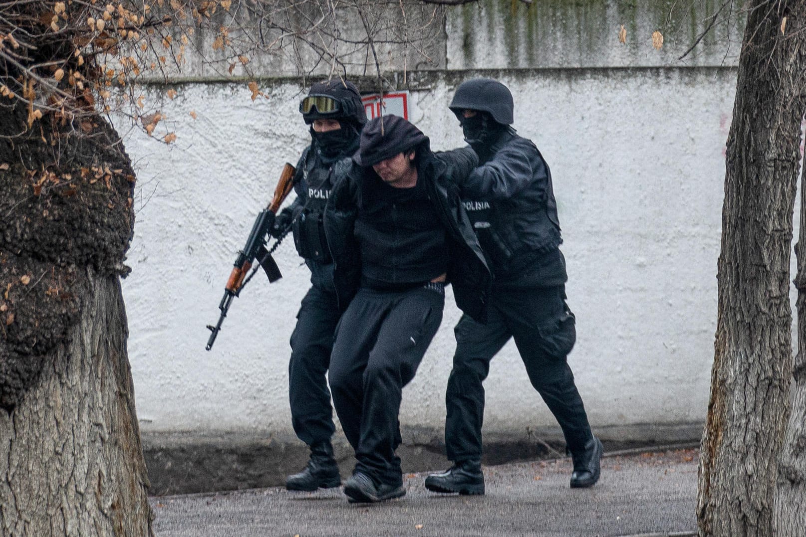 Bewaffnete Bereitschaftspolizisten halten einen Demonstranten in Almaty fest: Die Unruhen in dem zentralasiatischen Land Kasachstan halten an.