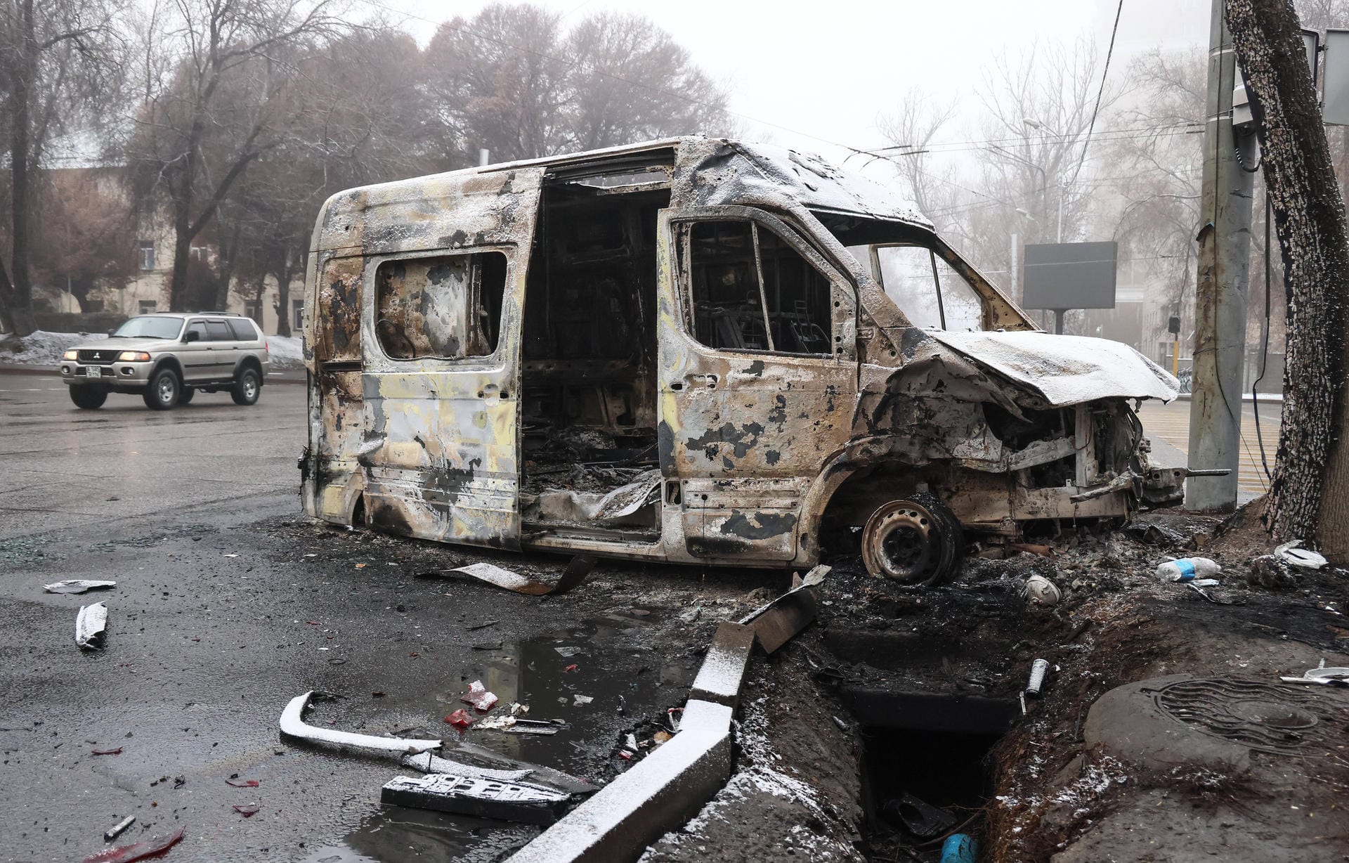 Ein heruntergebrannter Minibus in den Straßen von Almaty: Das Innenministerium von Kasachstan schätzte den Sachschaden im Land auf umgerechnet rund 175 Millionen Euro.