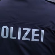 "Polizei" steht auf der Uniform eines Polizisten (Symbolbild): Bei einem Mann wurden gefälschte Dokumente gefunden.