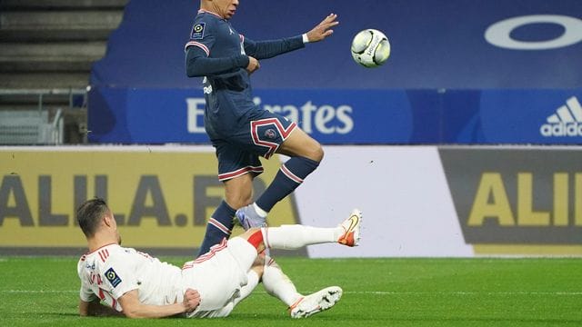 Kylian Mbappe (oben) von PSG und Damien Da Silva von Olympique Lyon kämpfen um den Ball.