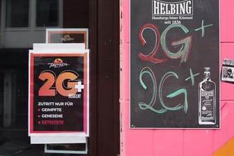 Ein Schild mit der Aufschrift "2G+" hängt in einem Fenster einer Gaststätte (Symbolbild): Geboosterte sind von der Testpflicht ausgenommen.