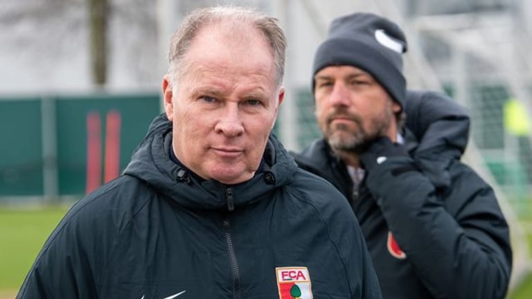 Sportdirektor Stefan Reuter (l) und Trainer Markus Weinzierl stehen bei einem Training des FC Augsburg auf dem Trainigsgelände.