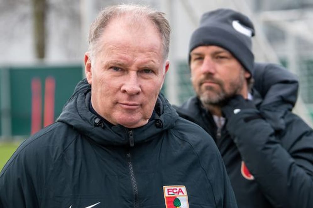 Sportdirektor Stefan Reuter (l) und Trainer Markus Weinzierl stehen bei einem Training des FC Augsburg auf dem Trainigsgelände.