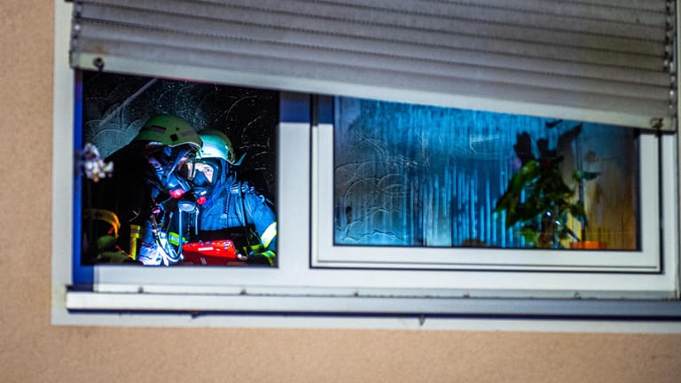 Feuerwehrleute arbeiten in einer Wohnung: In einer Wohnung in Soest hat am späten Sonntagnachmittag ein Weihnachtsbaum Feuer gefangen und einen Wohnungsbrand ausgelöst.