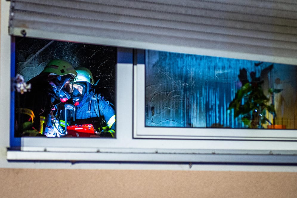 Feuerwehrleute arbeiten in einer Wohnung: In einer Wohnung in Soest hat am späten Sonntagnachmittag ein Weihnachtsbaum Feuer gefangen und einen Wohnungsbrand ausgelöst.