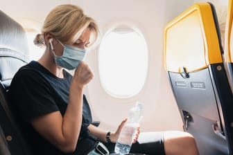 Passagierin hustet im Flugzeug (Symbolbild): Ein Beitrag auf Reddit hat Empörung ausgelöst.
