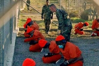 In orangefarbenen Overalls gekleidete Häftlinge im US-Gefangenenlager Guantánamo im Januar 2002.