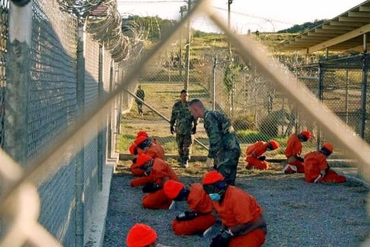 In orangefarbenen Overalls gekleidete Häftlinge im US-Gefangenenlager Guantánamo im Januar 2002.