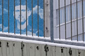 Ein Plakat mit dem Konterfei des serbischen Tennisspielers Novak Djokovic hängt an einem Gebäude.
