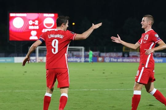Nationalspieler Jakub Kaminski (r) klatscht mit Robert Lewandowski ab.