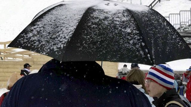 Zuschauer harren am Fuße der Sprungschanze in Planica aus.