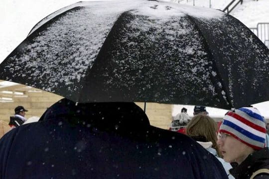 Zuschauer harren am Fuße der Sprungschanze in Planica aus.