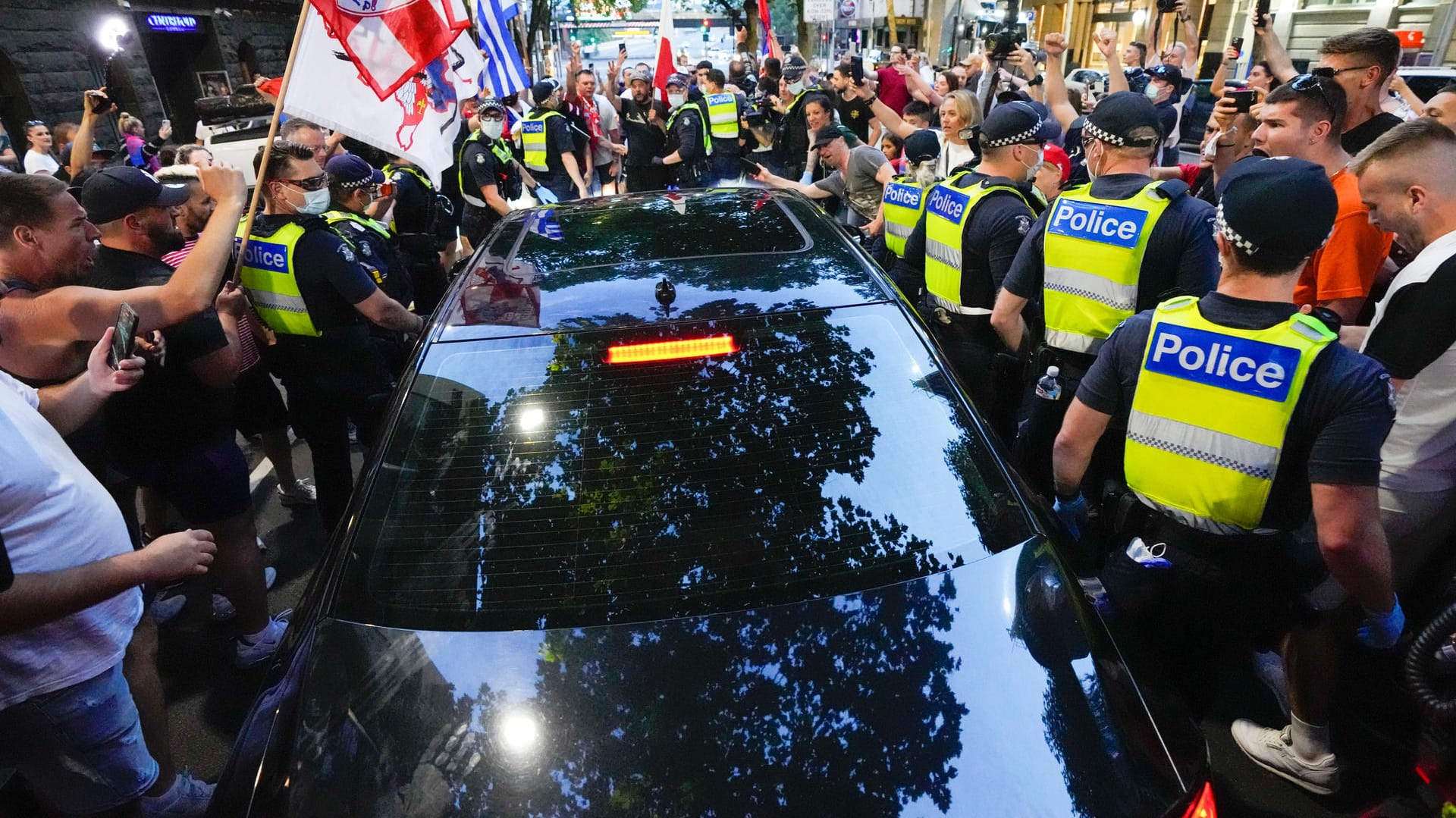 Fans umzingeln ein Auto in Melbourne, das das Bürogebäude von Djokovics Anwälten verlässt: Die Lage in Australien ist weiter unklar.