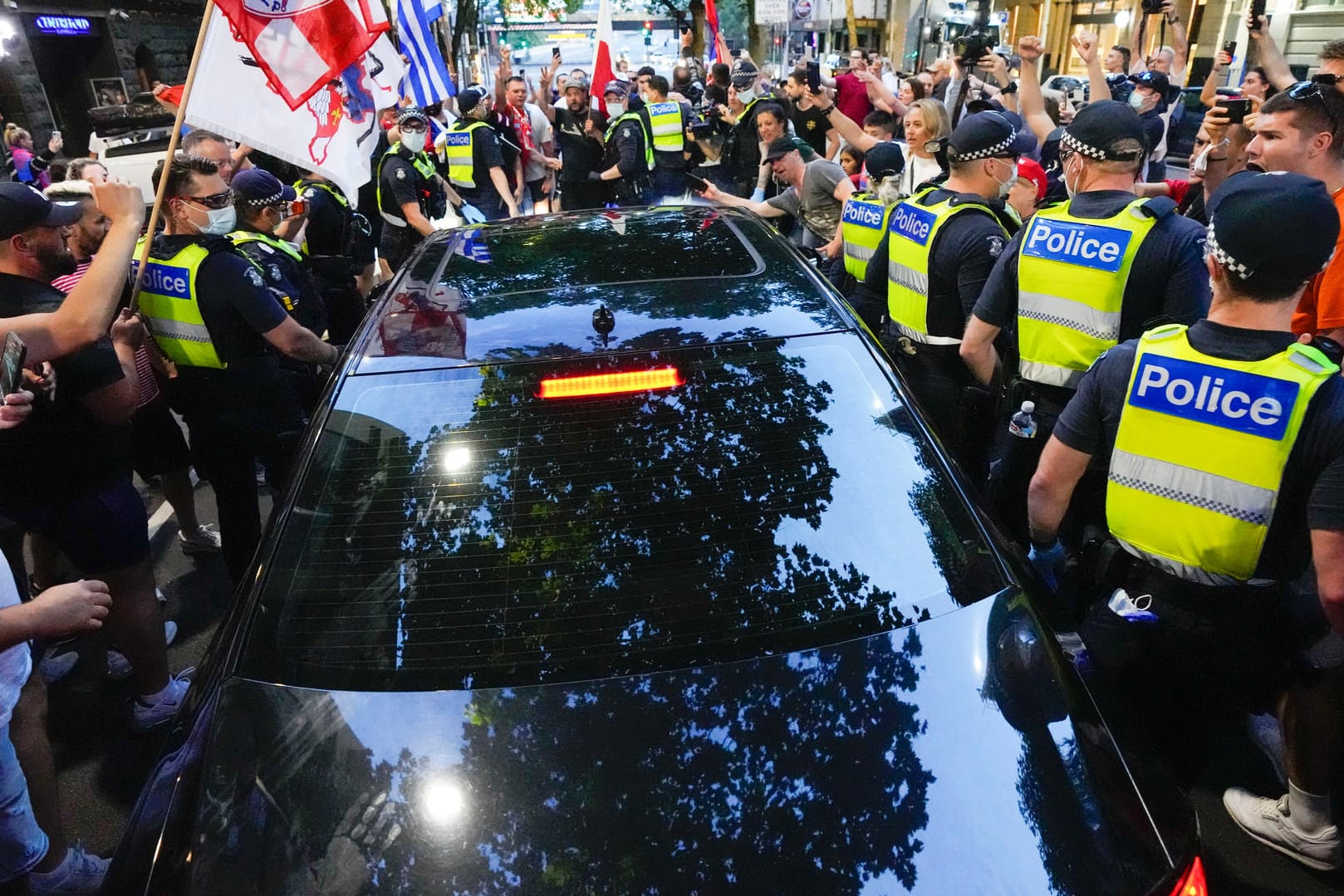 Fans umzingeln ein Auto in Melbourne, das das Bürogebäude von Djokovics Anwälten verlässt: Die Lage in Australien ist weiter unklar.