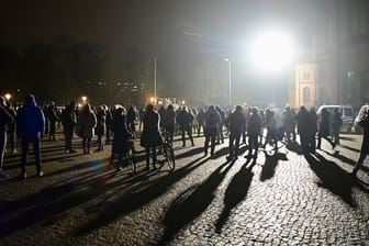 Demonstrierende stehen während einer Abschluss-Kundgebung gegen die Corona-Regeln auf dem Bassinplatz in Potsdam.