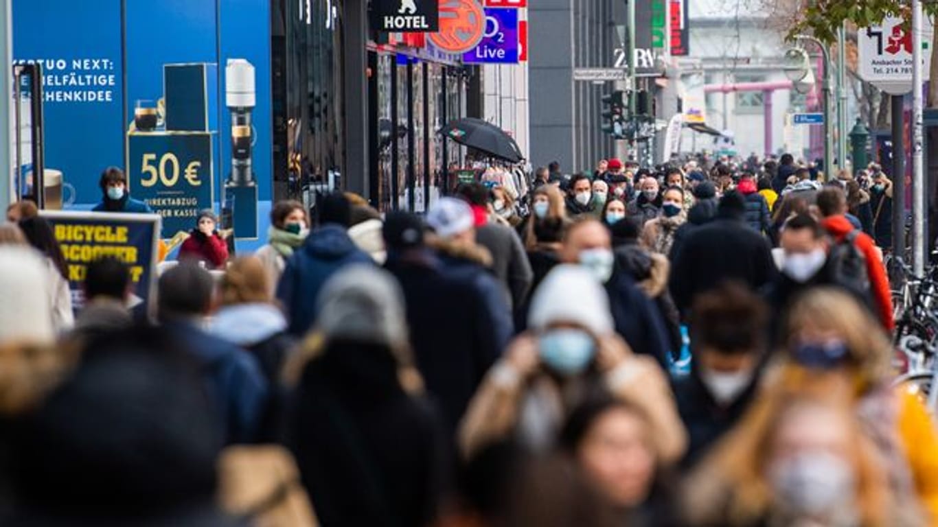 Zahlreiche Menschen mit Mund-Nasen-Schutz laufen auf einer Einkaufsmeile in Berlin.