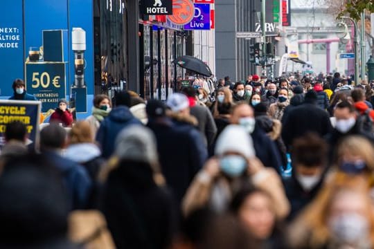 Zahlreiche Menschen mit Mund-Nasen-Schutz laufen auf einer Einkaufsmeile in Berlin.