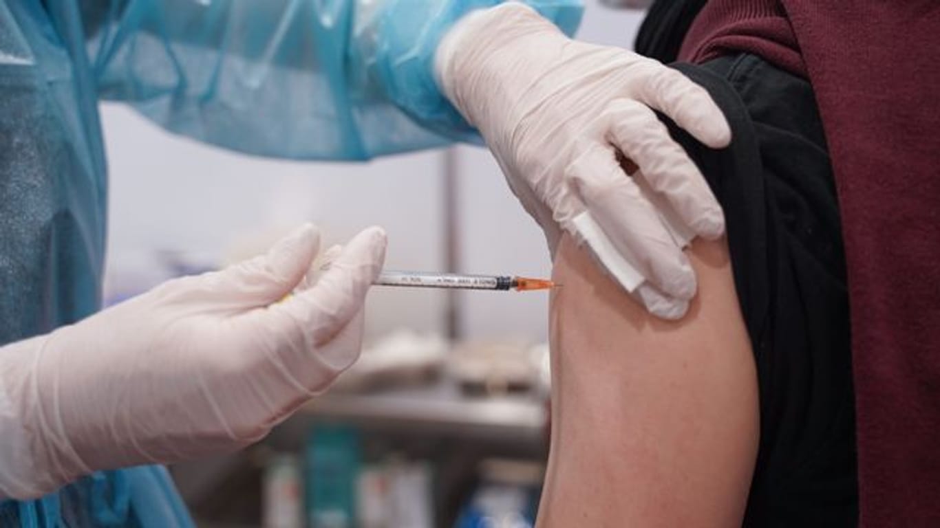 Ein junger Mann wird mit einer Booster-Dosis des Impfstoffs von Moderna geimpft.