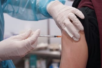 Ein junger Mann wird mit einer Booster-Dosis des Impfstoffs von Moderna geimpft.