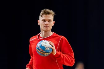Handball-Nationalspieler Timo Kastening hält einen Ball in der Hand.