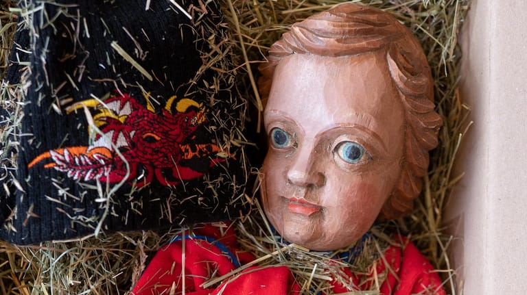 Eine Christkind-Figur aus Lindenholz liegt auf Heu in einem Paket: Das gestohlene Kunstwerk wurde nun zurückgegeben.