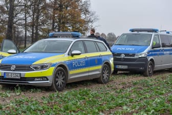 Zwei Einsatzwägen auf einem Feld (Archivbild): Ein 33-Jähriger hat sich in Sachsen eine Verfolgungsjagd mit der Polizei geliefert.