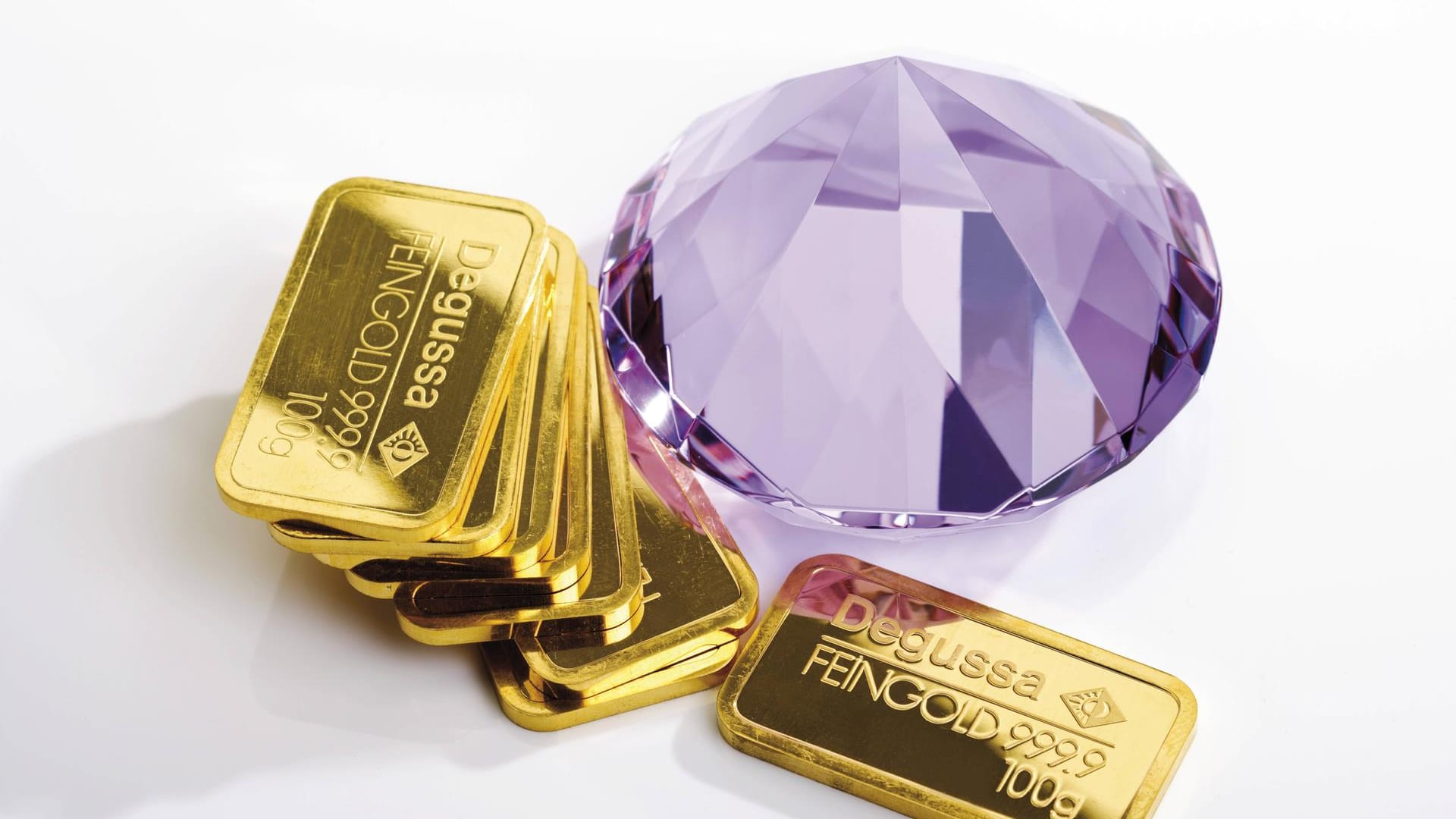 Ein Edelstein und Goldbarren (Symbolbild): Die Frau händigte eine Tasche voller Kostbarkeiten aus.