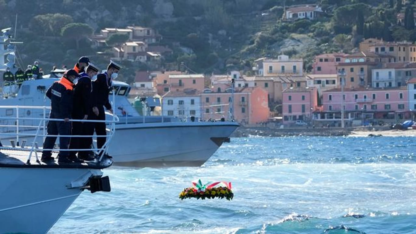 Matrosen lassen einen Blumenkranz zum Gedenken an die Opfer des Schiffsunglücks vor der Insel Giglio ins Meer.
