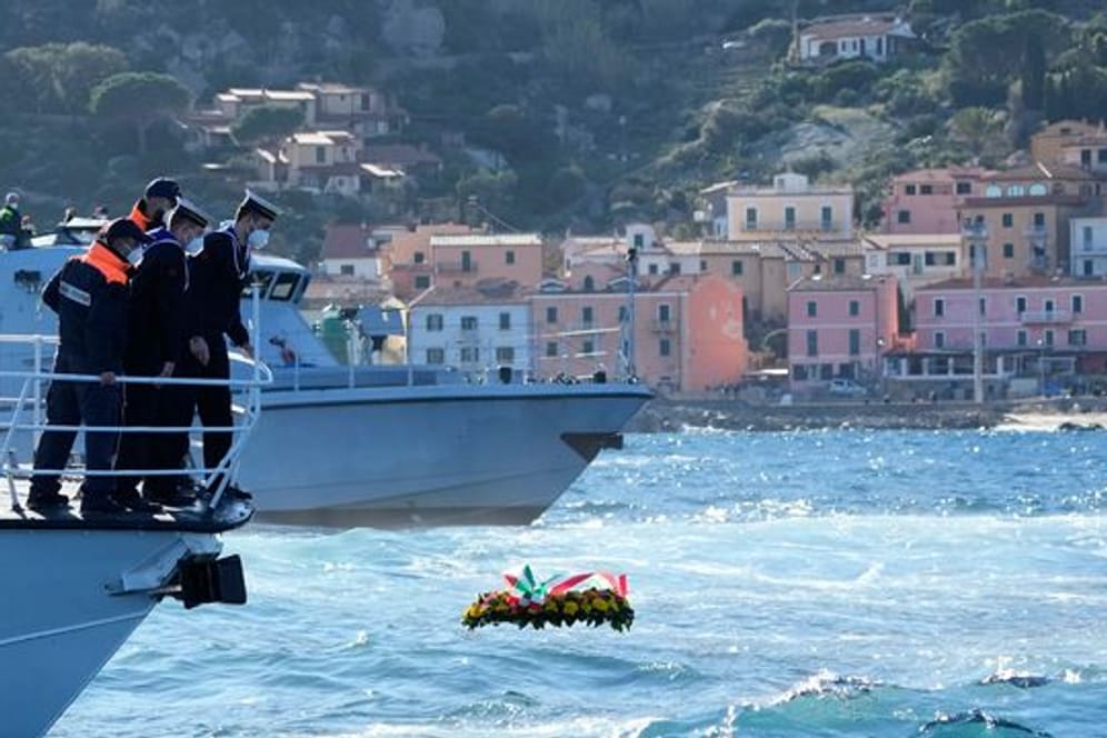 Matrosen lassen einen Blumenkranz zum Gedenken an die Opfer des Schiffsunglücks vor der Insel Giglio ins Meer.