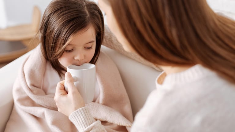 Kind trinkt Tee: Bei Husten ist es wichtig, ausreichend zu trinken, damit die Atemwege nicht zu trocken werden.