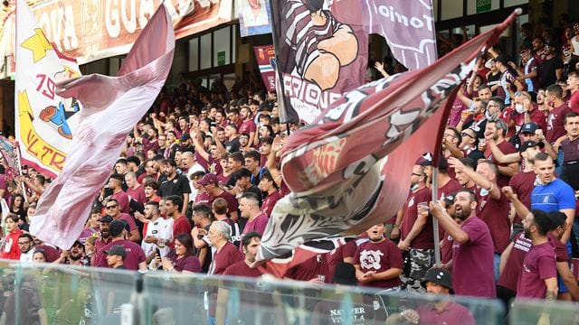 Fans von Salernitana jubeln auf der Tribüne während eines Fußballspiels ihrer Mansnchaft.